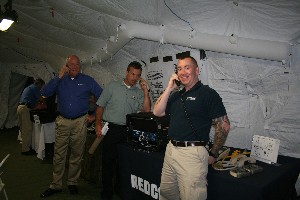 Charles McMurray (l), business development director, government markets, REDCOM Laboratories Incorporated; James Appleyard (c), director, business development, L-3 Communications; and Steve Moses, government integration engineer, REDCOM Laboratories Incorporated, test a tactical communications system during the August TechNet event.